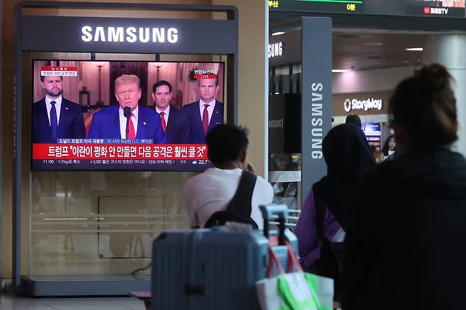 22일 서울역 대합실에서 시민들이 이란 공습 관련 미국 트럼프 대통령의 대국민 연설 방송을 시청하고 있다. [연합]
