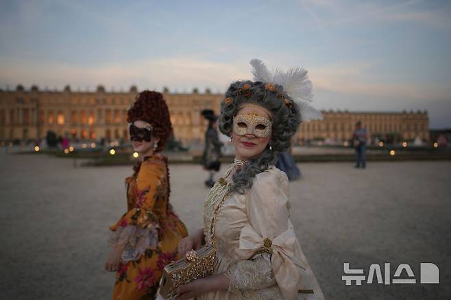 [베르사유=AP/뉴시스] 21일(현지 시간) 프랑스 파리 베르사유 궁전 오랑주리에서 열린 가면 무도회에 참가한 참가자들이 이동하고 있다. 2025.06.23.<font style="vertical-align: inherit;"><font style="vertical-align: inherit;"></font></font>