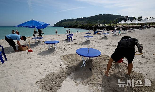 [제주=뉴시스] 우장호 기자 = 제주도 내 해수욕장 조기 개장을 하루 앞둔 23일 오전 제주시 조천읍 함덕해수욕장에서 피서객을 위한 파라솔 설치 작업이 한창이다. 2025.06.23. woo1223@newsis.com