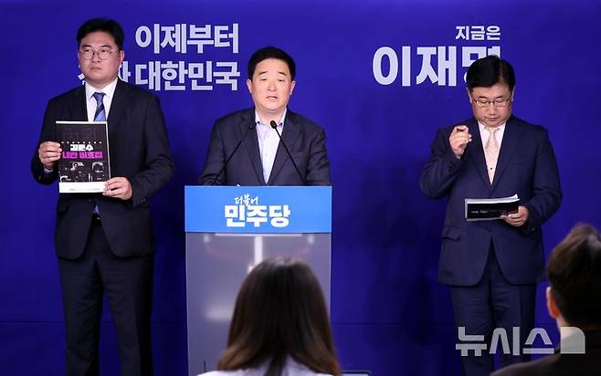 [서울=뉴시스] 조성봉 기자 = 강득구 더불어민주당 신속대응단장이 13일 오전 서울 여의도 중앙당사에서 '김문수 국민의힘 대선후보 내란비호집'을 공개하고 있다. 왼쪽부터 정준호 신속대응단 부단장, 강 단장, 박관천 신속대응부단장. 2025.05.13. suncho21@newsis.com