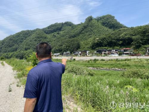 ◇김영덕 홍천군 내촌면 화상대1리 이장. 장마철 고립되는 쌍둔지길 일대를 소개하고 있다. 폭우가 쏟아지면 하천에서 물이 5m 넘게 불어나 마을 일대가 모두 잠긴다. 사진=손지찬 기자