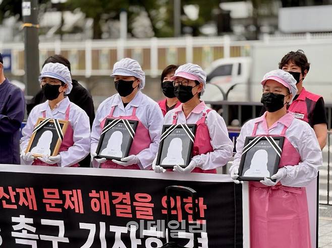 민주노총 학비노조가 24일 연 ‘학교급식법 개정 촉구 기자회견’에서 참가자들이 영정과 국화를 들고 있다. (사진제공=민주노총)