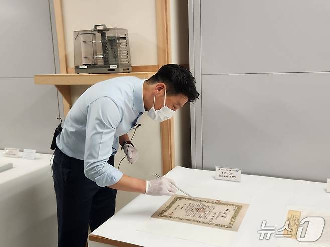 충남 계룡대의 육군기록정보관리단 관계자가 용문산 전투 중 수여된 문맹 장병 한글 교육 관련 표창장에 대해 설명하고 있다. 2025.06.23 ⓒ 뉴스1 김예원 기자