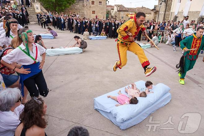 22일(현지시간) 스페인 부르고스 인근 카스트리요 드 무르시아 마을에서 열린 '엘 콜라초(El Colacho)'축제에서 악마를 상징하는 '콜라초'가 아기들을 뛰어넘고 있다.ⓒ AFP=뉴스1