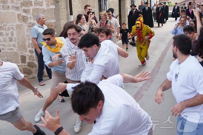 22일(현지시간) 스페인 부르고스 인근 카스트리요 드 무르시아 마을에서 열린 '엘 콜라초(El Colacho)'축제에서 참가자들이 악마를 상징하는 '콜라초'를 놀리며 추격전을 벌이고 있다. ⓒ AFP=뉴스1