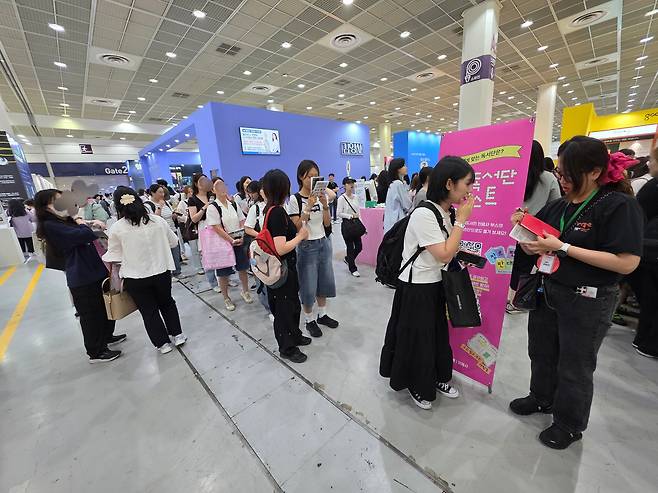 서울국제도서전 개막일인 지난 18일, 민음사 부스 앞에서 조아란 마케팅 부장에게 사인을 받으려는 독자들이 긴 줄을 서 있다./곽아람 기자