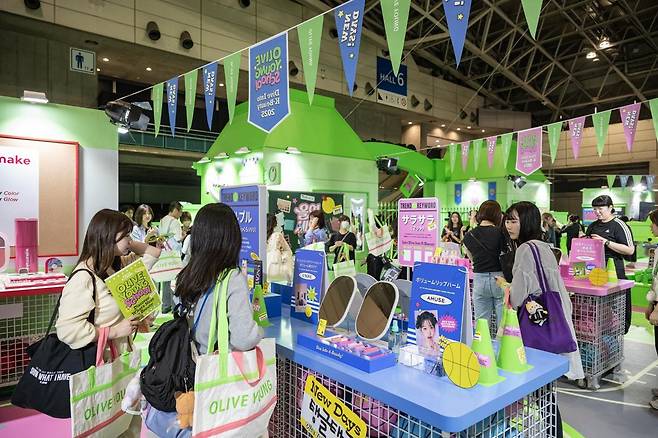 지난달 9~11일 일본 도쿄 인근 지바현 마쿠하리 멧세 ‘케이콘 저팬(KCON JAPAN) 2025’ 현장에 마련된 CJ올리브영 부스에서 일본인 관람객들이 한국 화장품을 둘러보고 있다. CJ올리브영 제공
