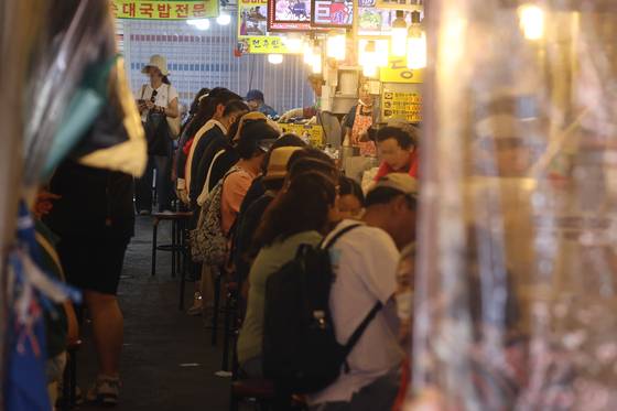 서울 남대문시장에서 시민들과 관광객들이 상점을 둘러보고 있다. 정부가 2차 추가경정예산안으로 전 국민에게 15~50만원씩 민생회복 소비쿠폰을 지급하기로 하면서 소비 진작 효과에 이목이 쏠린다. [연합뉴스]