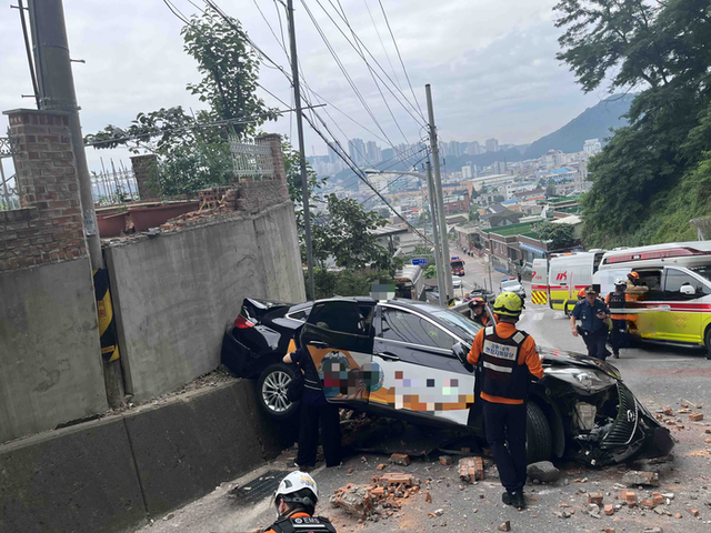 ▲ 24일 오후 2시 38분쯤 삼척시 당저동에서 택시 한 대가 주차를 하던 중 벽을 뚫고 3m 아래로 추락하는 사고가 났다. 강원소방본부 제공