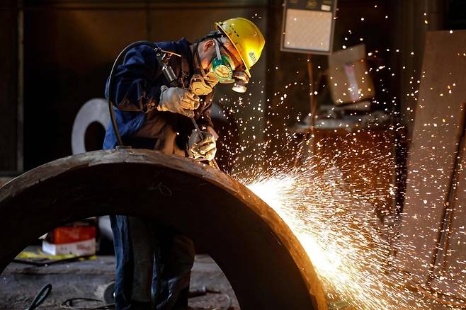 지난 16일 중국 저장성 항저우의 한 기계제조회사에서 한 근로자가 철강 부품을 연마하는 모습 / 사진=AFP 연합