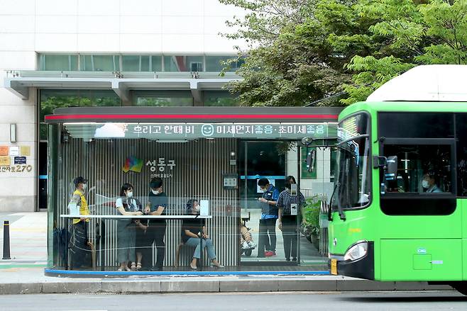 서울 성동구가 2020년 8월 전국 최초로 설치한 미래형 버스정류장인 ‘스마트쉼터’에서 주민들이 버스를 기다리고 있다. 성동구청 제공