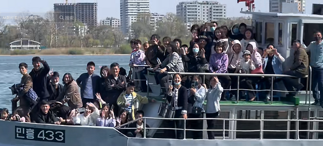 지난 4월 북한 유람선이 북한 주민들을 태운채 운행중인 가운데 탑승한 북한 주민들이 중국 단둥쪽을 향해 손을 흔들고 있다. [더우인 캡처]