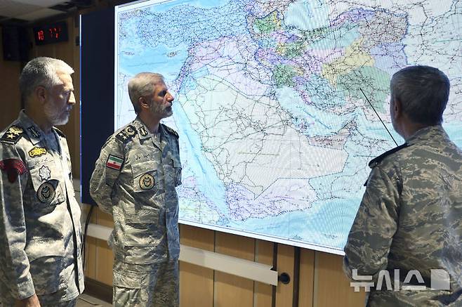 [테헤란=AP/뉴시스] 아미르 하타미(가운데) 이란 육군 총사령관이 6월23일(현지 시간) 이란 내 줄피카르 중앙사령부에서 고위 지휘관들과 지도를 보면서 회의하고 있다. 하타미 사령관은 이 자리에서 시온주의자(이스라엘)에게 다시 타격을 가하겠다고 밝혔다. 2025.06.24.
