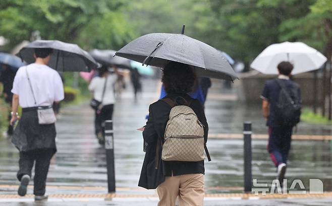 [서울=뉴시스] 권창회 기자 = 본격적인 장마가 시작된 20일 서울 여의도역 인근에서 시민들이 우산을 쓰고 이동하고 있다. 2025.06.20. kch0523@newsis.com
