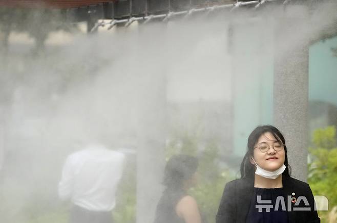 [도쿄=AP/뉴시스]지난해 7월 4일 일본 도쿄에서 더위를 식히기 위해 마련된 '쿨링 미스트 스팟'을 시민들이 지나가고 있다. 2025.05.20.