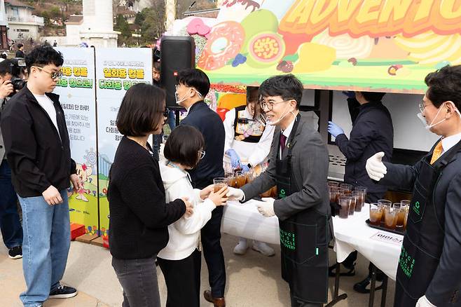 [서울=뉴시스] 김진아 기자 = 김완섭 환경부 장관이 25일 오후 경기도 용인시 에버랜드에서 ‘에버랜드 맞춤형 일회용 컵 사용감량을 위한 자발적 협약’을 체결 후 놀이동산 방문객들에게 다회용 컵에 음료를 나누어 주며 회수함에 반납해 줄 것을 안내하고 있다. (사진=환경부 제공) 2025.03.25. photo@newsis.com *재판매 및 DB 금지