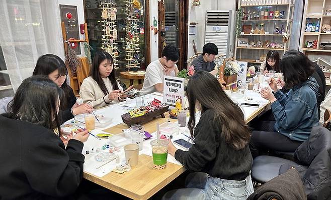 [아산=뉴시스] 둔포출장나와유에서 청년심리케어 활동으로 고양이 나무 키링을 만들고 있는 청년들.(사진=아산시 제공).2025.06.24.photo@newsis.com. *재판매 및 DB 금지