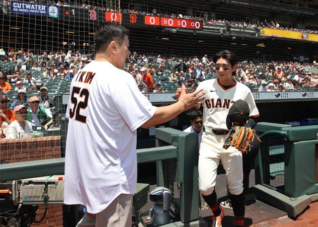한화 이글스 영구결번인 김태균(왼쪽) 해설위원과 이정후 선수가 22일(현지 시간) 미 샌프란시스코 오라클파크에서 열린 보스턴 레드삭스와의 홈경기 시작에 앞서 시구를 위한 인사를 나누고 있다. 사진제공=한화생명