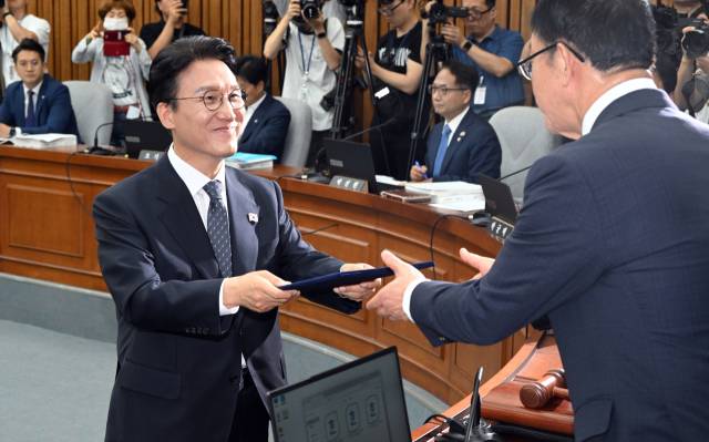 김민석 국무총리 후보자가 24일 국회에서 열린 인사청문회에 출석해 선서한 뒤 이종배 위원장에게 선서문을 제출하고 있다. 오승현 기자 2025.06.24