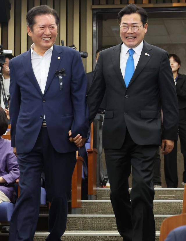 당 대표 선거 출마를 선언한 정청래(왼쪽)·박찬대 더불어민주당 의원이 24일 국회에서 열린 의원총회에 손을 잡고 참석하고 있다. 오승현 기자 2025.06.24