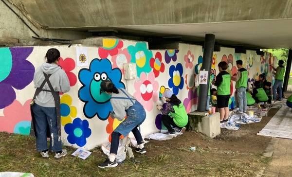 ▲ 홍성군 보듬손길 모두가족봉사단과 홍동중학교 학생들의 벽화봉사활동 모습. 사진=정윤우 명예기자