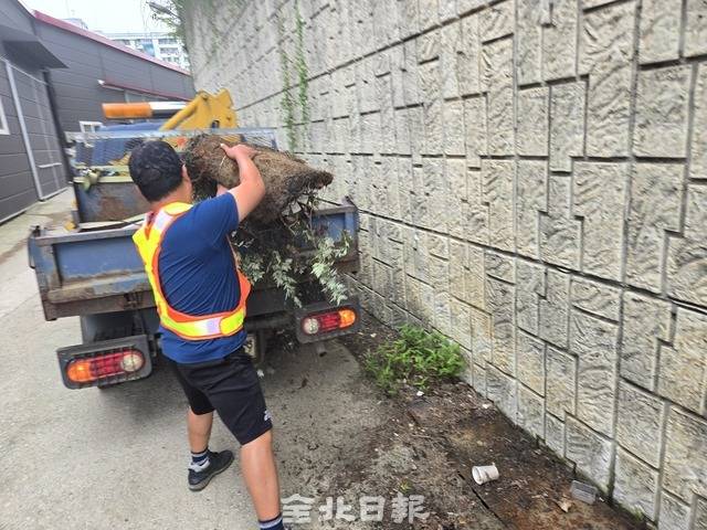 장연승 반장이 하수구 위에 놓여진 깔개를 치우고 있다. 김경수 기자
