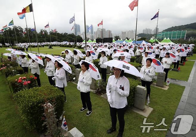 25일 오전 부산 남구 유엔기념공원에서 열린 제75주년 6·25전쟁 참전 유엔전몰용사 추모제에서 태극기 우산을 쓴 참석자들이 유엔군 전몰장병 묘역을 참배하고 있다. 2025.6.25/뉴스1 ⓒ News1 윤일지 기자