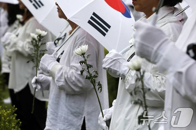25일 오전 부산 남구 유엔기념공원에서 열린 제75주년 6·25전쟁 참전 유엔전몰용사 추모제에서 태극기 우산을 쓴 참석자들이 유엔군 전몰장병 묘역을 참배하고 있다. 2025.6.25/뉴스1 ⓒ News1 윤일지 기자