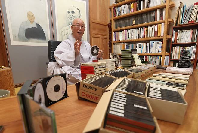 원택 스님이 1967년 성철 스님의 ‘백일법문’ 원본 릴테이프를 들고 있다. 원택 스님은 백일법문 테이프를 들으며 한 글자씩 옮겨 적어 47년 만에 ‘백일법문’을 책으로 완간했다. 원택 스님 뒤의 그림은 김호석 화백이 그린 성철 스님 초상. /김동환 기자