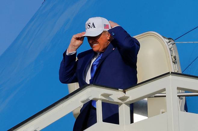 도널드 트럼프 미국 대통령이 24일 네덜란드 스키폴의 암스테르담 스키폴 공항에 도착해 에어포스원에서 내리며 모자를 고쳐 쓰고 있다. 로이터/암스테르담 연합뉴스