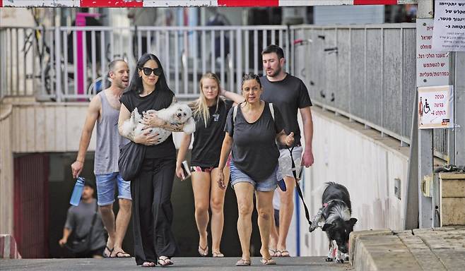 <공습경보 끝나나> 이스라엘 텔아비브 시민들이 24일 이란의 미사일 공습 경보가 끝난 뒤 피란처인 지하주차장에서 나오고 있다. AP연합뉴스