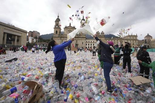 시위자들이 플라스틱 봉지에 가득 담아온 플라스틱 병을 하늘로 흩뿌리고 있다. AP연합뉴스