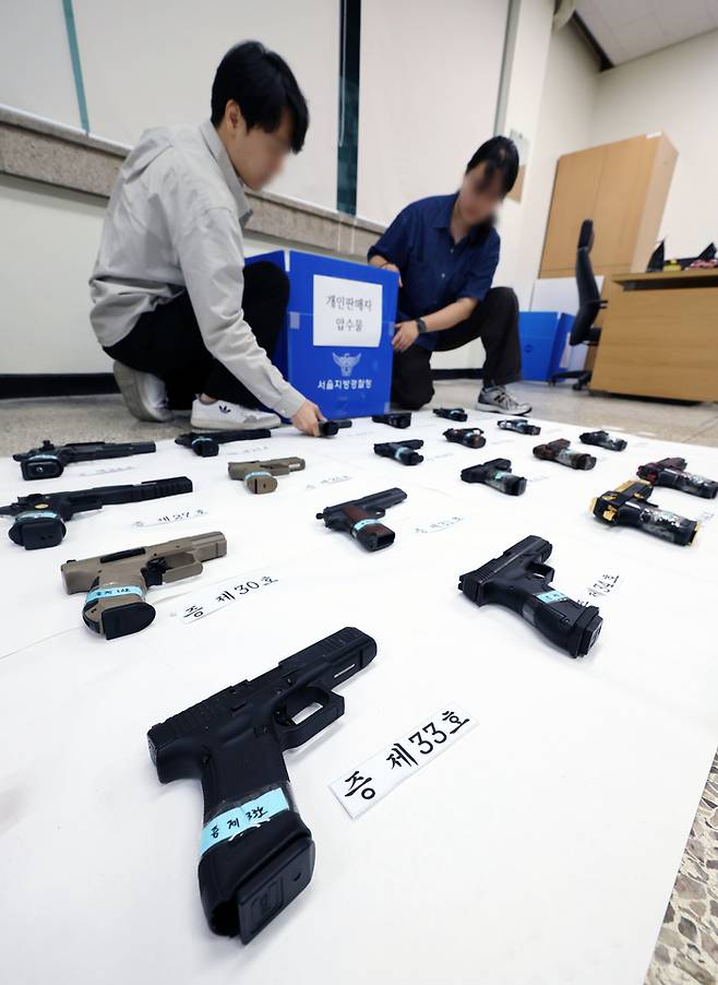 25일 서울 동대문구 서울경찰청 장한로 별관에서 서울경찰청 범죄예방질서과 풍속범죄수사팀이 압수한 모의총포들을 정리하고 있다. [연합뉴스]