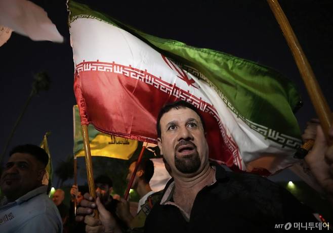 [바그다드=AP/뉴시스] 24일(현지 시간) 이라크 바그다드에서 이란 국기를 든 시위대가 이라크 주재 이란 대사관 앞에 모여 이란과 이스라엘의 휴전을 환영하고 있다. 2025.06.25. /사진=민경찬