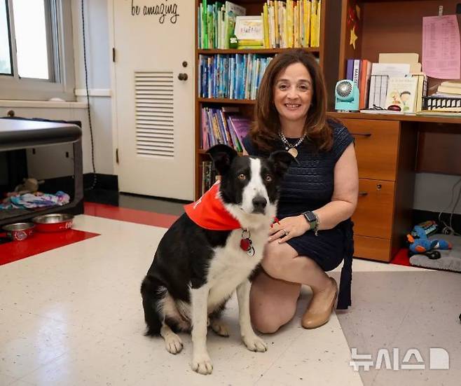 [뉴시스] 미국 뉴욕주 롱아일랜드의 한 초등학교가 훈련견을 도입해 거위 퇴치에 나섰다. 사진은 마이클 F. 스토크스 초등학교 앨리슨 애커먼 교장과 훈련견 턱의 모습. (사진=뉴욕포스트) 2025.06.23