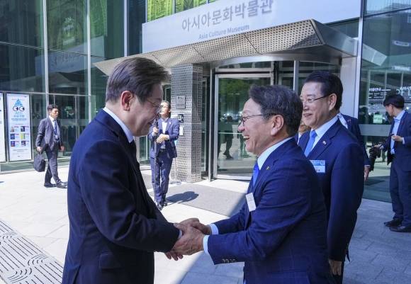 이재명 대통령(왼쪽)이 25일 광주 국립아시아문화전당에서 열린 ‘광주시민·전남도민 타운홀 미팅’에  참석한 강기정 광주시장과 악수를 하고 있다. 광주광역시 제공