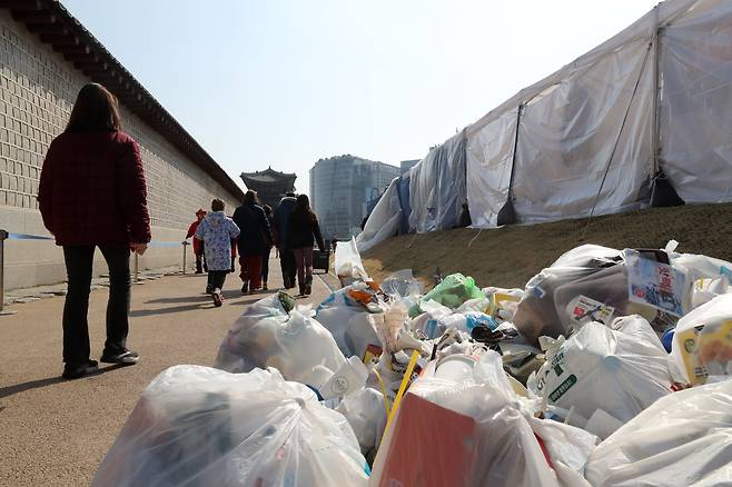 3월 31일 오전 경복궁 앞에 설치된 더불어민주당 천막당사 뒤에 쓰레기가 널브러져 있는 가운데 외국인 관광객들이 지나고 있다. /조선DB