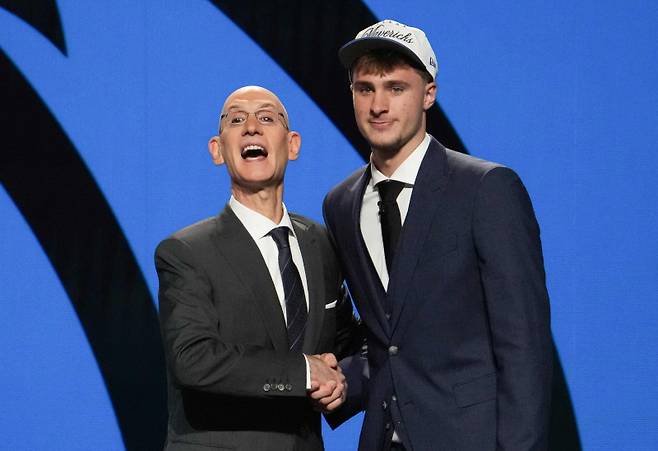 <yonhap photo-3299=""> US basketball player Cooper Flagg (R) shakes hands with NBA Commissioner Adam Silver after being selected first overall by the Dallas Mavericks during the opening round of the 2025 NBA Draft at Barclays Center in Brooklyn, New York, on June 25, 2025. Versatile US college teen star Cooper Flagg was selected first overall in the NBA draft on June 25 by the Dallas Mavericks, where he'll join a star-laden team already touted as a playoff threat next season. Flagg, a consensus pick as the top US college player as a freshman at Duke University last season, is the second-youngest player taken first overall. (Photo by TIMOTHY A. CLARY / AFP)/2025-06-26 09:30:03/ <저작권자 ⓒ 1980-2025 ㈜연합뉴스. 무단 전재 재배포 금지, AI 학습 및 활용 금지></yonhap>