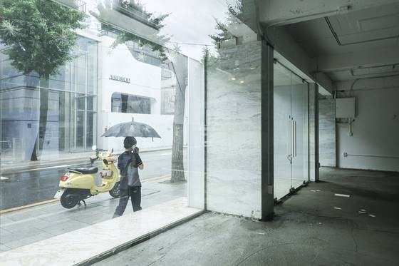 25일 서울 강남구 신사동 가로수길에서 한 시민이 텅 빈 상가를 지나가고 있다. 김경록 기자