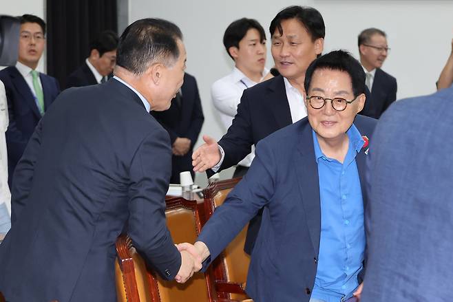 국민의힘 소속 신성범 국회 정보위원장이 지난 23일 국회에서 열린 정보위 전체회의에서 박지원 더불어민주당 의원과 악수하고 있다. 연합뉴스