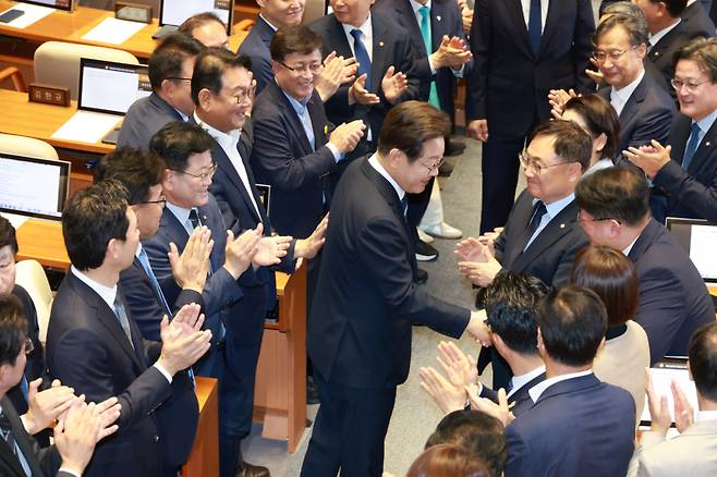 이재명 대통령이 26일 서울 여의도 국회 본회의장에서 2025년도 제2회 추가경정예산안에 대한 정부의 시정연설을 하기 위해 입장하며 더불어민주당 의원들과 인사하고 있다.