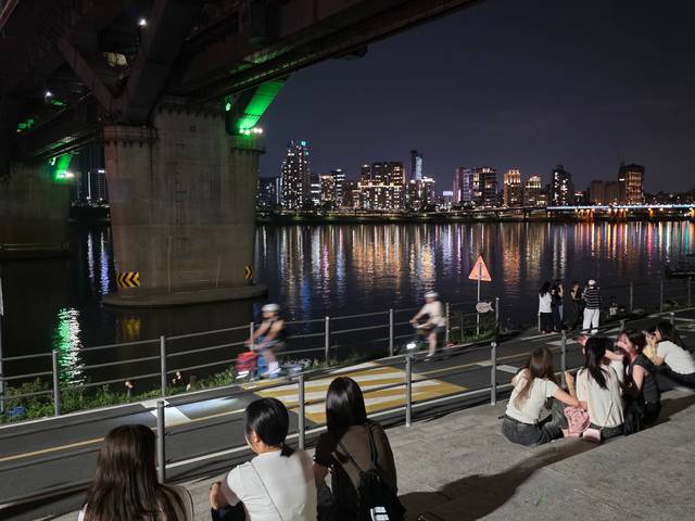 시민들이 지난 23일 서울 광진구 뚝섬한강공원에 모여있는 가운데 자전거 운전자들이 빠른 속도로 자전거도로를 달리고 있는 모습.