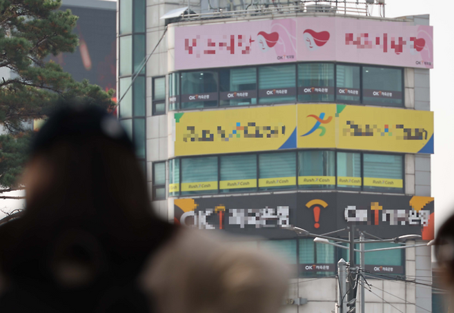 서울역 인근 상가에 밀집한 대부업체 간판 아래로 한 시민이 지나고 있다. [한주형 기자]