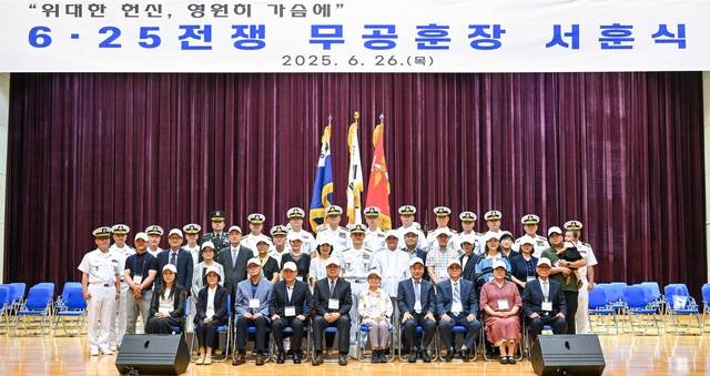 26일 충남 계룡대 해군본부에서 열린 6·25전쟁 무공훈장 서훈식에서 양용모 해군참모총장을 비롯한 해군 관계자들과 10명의 무공훈장 서훈 유가족들이 함께 기념촬영하고 있다. 해군 제공