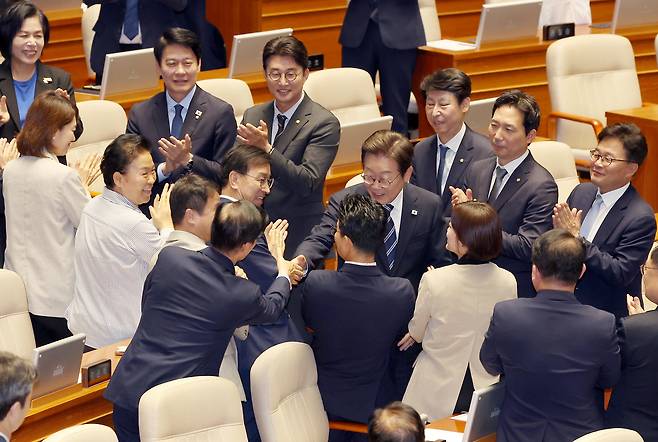 이재명 대통령이 26일 추가경정예산 시정연설을 위해 국회 본회의장에 입장해 더불어민주당 의원들과 인사하고 있다. [연합]