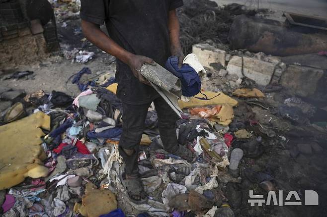 <font style="vertical-align: inherit;"><font style="vertical-align: inherit;">[가자시티=AP/뉴시스] 지난 22일(현지 시간) 가자지구 가자시티 남쪽 시로드에서 팔레스타인 청년이 연료 추출용 플라스틱을 모으고 있다. 팔레스타인 청년들은 플라스틱 폐기물을 금속 드럼에 넣고 가열해 만든 연료를 병에 담아 판매하며, 이는 현지에서 발전기나 이동용 연료로 사용된다. 유독한 연기와 불길에 노출되는 고된 작업이지만, 이들에게는 가족의 생계를 이어가는 거의 유일한 수단이다. 2025.06.25.</font></font>