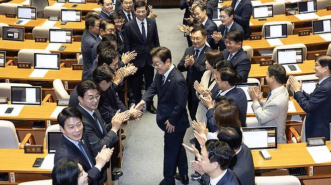 이재명 대통령이 26일 국회에서 추가경정예산 시정연설을 위해 본회의장에 입장해 더불어민주당 의원들의 박수를 받으며 인사하고 있다.