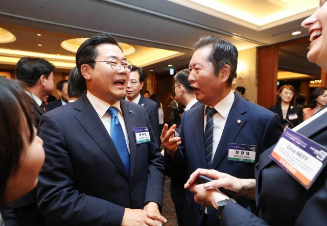 더불어민주당 당 대표에 출마한 정청래 의원과 박찬대 의원이 25일 서울 중구 롯데호텔에서 열린 '2025 경향포럼'에서 내빈들과 인사하고 있다. / 연합뉴스