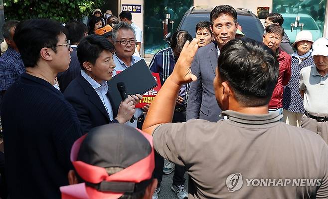 광주 자원회수시설 관련 주민설명회 무산 (광주=연합뉴스) 조남수 기자 = 26일 오후 광주 광산구 삼도동 행정복지센터에서 열릴 예정이던 자원회수(소각)시설 환경영향평가 초안 주민설명회에 참석하려던 광주시 관계자가 행사장 밖에서 주민들과 대화하고 있다. 2025.6.26 iso64@yna.co.kr