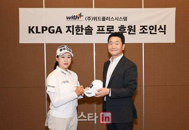지한솔(왼쪽)과 김승모 위드플러스시스템 대표이사가 후원 계약식에서 모자를 교환하고 있다. (사진=WP스포테인먼트)